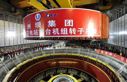 12月15日,三峽地下電站32號(hào)機(jī)組轉(zhuǎn)子正在進(jìn)行吊裝。當(dāng)日,三峽地下電站32號(hào)機(jī)組轉(zhuǎn)子成功吊裝到位,首臺(tái)機(jī)組將于明年汛前投產(chǎn)發(fā)電。地下電站設(shè)計(jì)安裝6臺(tái)70萬(wàn)千瓦機(jī)組,將成為三峽大壩左、右岸26臺(tái)機(jī)組的有效補(bǔ)充。屆時(shí),三峽電站32臺(tái)機(jī)組總?cè)萘繉⑦_(dá)2250萬(wàn)千瓦,年最大發(fā)電能力約為1000億千瓦時(shí)。新華社發(fā)(鄭家裕 攝)