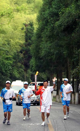 5月15日,奧運(yùn)火炬手周艷軍手持火炬?zhèn)鬟f。當(dāng)日,北京奧運(yùn)會(huì)圣火傳遞活動(dòng)在江西井岡山舉行。新華社記者 邢廣利 攝