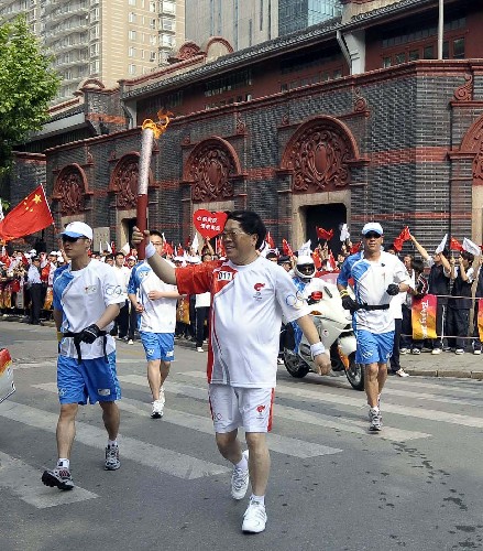 5月23日,火炬手包起帆手持火炬?zhèn)鬟f。當(dāng)日,北京奧運(yùn)會(huì)圣火在上海傳遞。 新華社記者 戚恒 攝
