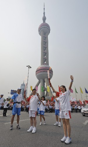 5月23日,火炬手陳露(前右)與火炬手裴曉在傳遞過(guò)程中進(jìn)行交接。當(dāng)日,北京奧運(yùn)會(huì)圣火在上海傳遞。新華社記者 戚恒 攝