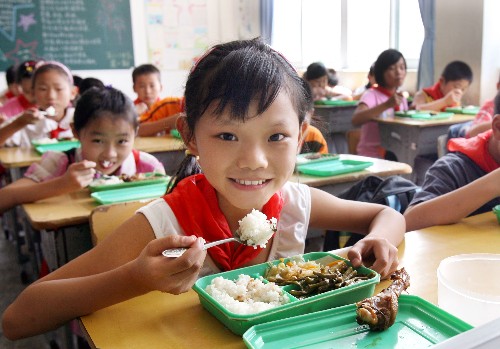 9月1日,老家在河南的小學(xué)生馮碩碩(前)在學(xué)校吃午餐。新華社記者 劉穎 攝
