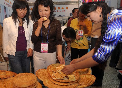 9月1日,幾位客商在品嘗維吾爾族傳統(tǒng)食品“馕”。當日,第十七屆烏魯木齊對外經(jīng)濟貿(mào)易洽談會開幕,吸引上萬名國內(nèi)外展商與會。本屆烏洽會展覽規(guī)模增加到1.88萬平方米,館內(nèi)外標準展位達到2090個,創(chuàng)歷史新高。展會設(shè)有建材家居、五金化工、機械汽配、紡織服裝、食品醫(yī)保、大型機械設(shè)備等專業(yè)展區(qū)。新華社記者 趙戈 攝