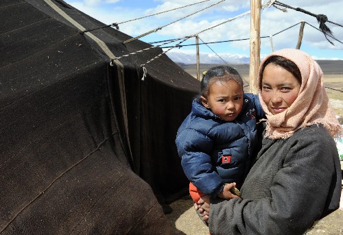 西藏當(dāng)雄地震震中羊易村的村民敏珠抱著孩子在臨時(shí)安置帳篷前(10月15日攝)。拉薩市當(dāng)雄縣10月6日發(fā)生6.6級地震后,西藏各部門迅速投入到抗震救災(zāi)中,及時(shí)將救災(zāi)物資送到災(zāi)區(qū)群眾手中。目前,災(zāi)區(qū)群眾生活逐步恢復(fù)正常,為安全過冬做好了準(zhǔn)備。新華社記者 格桑達(dá)瓦 攝