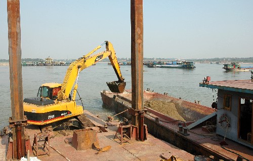 10月15日,在湘江主航道湘潭馬家河段,工作人員正使用挖沙船和挖土機(jī)進(jìn)行疏浚作業(yè)。湖南湘江進(jìn)入枯水期以來水位驟降,致使株洲至長沙段水位已低于船舶通航設(shè)計(jì)水位,部分航道船行受阻。近日,湖南省航道部門開始對影響湘江航運(yùn)的主要灘險(xiǎn)“瓶頸”展開大規(guī)模疏浚。 新華社記者 周青梅 攝