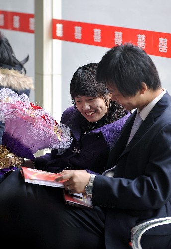 2月14日,一對新人在濟南市市中區(qū)婚姻登記大廳等候辦理結(jié)婚手續(xù)。新華社記者 朱崢 攝
