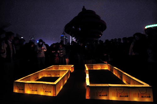 3月28日,市民在青島五四廣場(chǎng)上擺出一小時(shí)“60”分鐘的造型參加“地球一小時(shí)”活動(dòng)。當(dāng)晚8時(shí),青島市西起團(tuán)島,東至奧帆中心,包括沿海一線在內(nèi)的市內(nèi)四區(qū)的景觀燈全部關(guān)閉,為星光“讓路”。新華社記者 李紫恒 攝