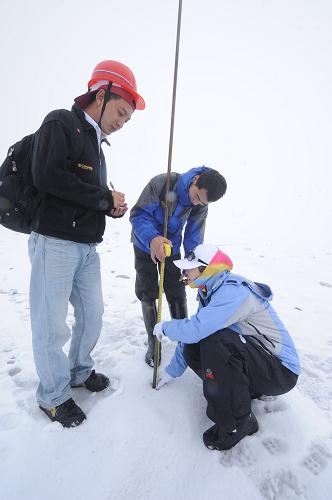 8月22日,中科院麗江玉龍雪山冰川與環(huán)境觀測站工作人員在海拔4800多米的地點測量花桿變化。新華社記者 秦晴 攝