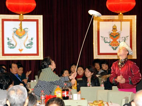 2月5日,來賓在茶話會上參加互動雜技表演《快樂廚房》。新華社記者 唐召明 攝