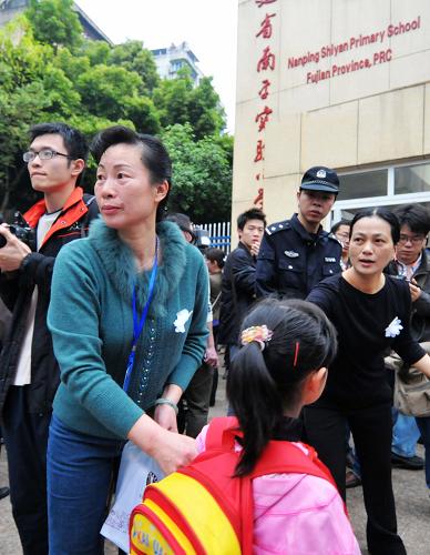 3月24日,福建南平實(shí)驗(yàn)小學(xué)教師在學(xué)校門口維持秩序迎接學(xué)生。新華社記者 魏培全 攝