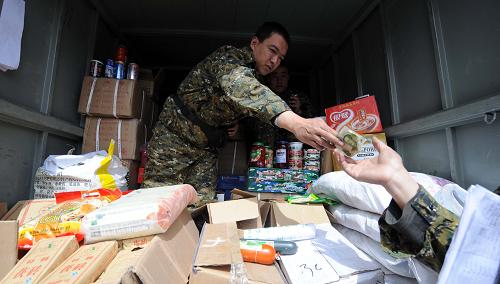 4月20日,一名工作人員在玉樹地震災區(qū)結(jié)古鎮(zhèn)商品銷售服務(wù)點提供零售服務(wù)。新華社記者 侯德強 攝