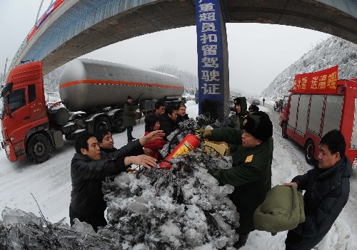 2月2日,湖南消防總隊(duì)郴州消防支隊(duì)的官兵正在為被堵油罐車(chē)輛的司機(jī)發(fā)放滅火器。 新華社記者 陳樹(shù)根 攝