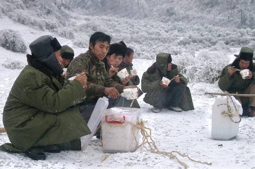 1月31日,搶修一線的電力職工在冰雪中用餐。 新華社記者 楊俊江 攝