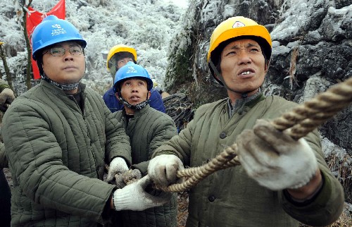 2月2日,在貴陽市圖云關(guān)的一條因雪凝災(zāi)害造成的110千伏輸電線路的損毀現(xiàn)場(chǎng),南方電網(wǎng)公司貴州送變電的搶險(xiǎn)人員正在架最后一相電。 新華社記者 楊楹 攝