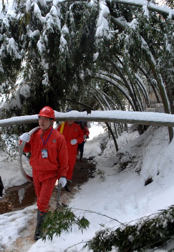 2月2日,供電搶險人員踏著積雪的山路為甘溪溝村的群眾搶修電力。 新華社記者 王雷 攝