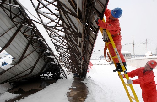 2月2日,廣德縣供電工作人員在一座被大雪壓垮的加油站內(nèi)檢查電路。 新華社記者 王雷 攝