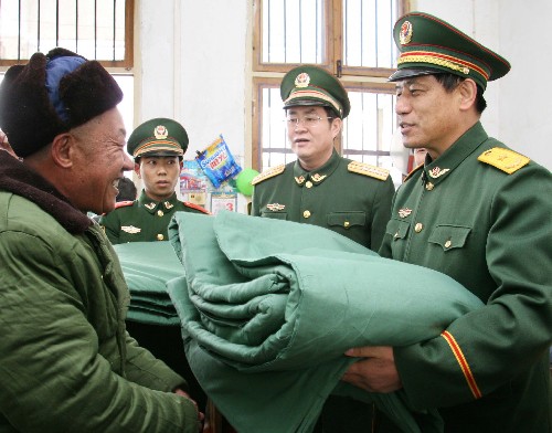 2月2日,武警安徽總隊(duì)官兵為雪災(zāi)重災(zāi)區(qū)合肥市肥西縣上派鎮(zhèn)四十埠社區(qū)群眾送年貨。 新華社發(fā)(廖福安 攝)