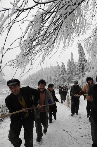 2月3日,在遭受雪凝災(zāi)害的貴陽市烏當區(qū)百宜鄉(xiāng)沙壩村,當?shù)剞r(nóng)民正在雪地里運送電線桿,搶修輸電線路。 新華社記者 楊楹 攝