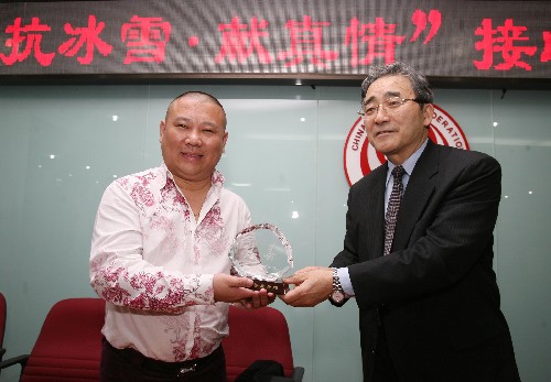 2月4日,著名相聲演員郭德鋼(左)代表“德云社”將前一天演出所得的10萬元捐出后,接過中華慈善總會(huì)會(huì)長范寶俊頒發(fā)的“慈善”水晶紀(jì)念品。 新華社記者 袁滿 攝