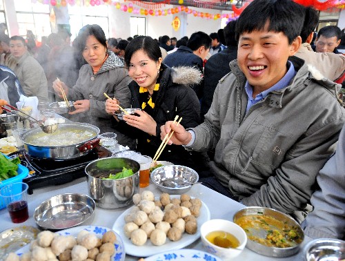 2月4日,佛山市一家外資企業(yè)的員工李春峰(前右一)和夫人楊艷(前右二)和同事們一起吃團(tuán)圓飯。李春峰、楊艷夫婦是河南人,他們?cè)I好回家與孩子和親人過(guò)年的火車票,由于災(zāi)害天氣的影響無(wú)法成行,最終決定留在佛山過(guò)春節(jié)。 新華社記者 陳學(xué)思 攝