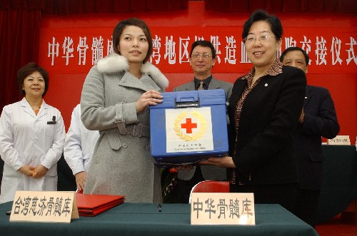 3月18日,在北京市道培醫(yī)院,中國紅十字會副會長蘇菊香(右)將造血干細胞儲運箱交給臺北榮民總醫(yī)院特別護士蕭詠之。 新華社記者 趙宇思 攝