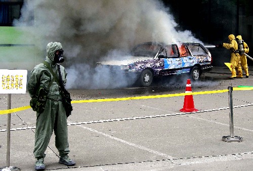 6月25日,專(zhuān)業(yè)反恐隊(duì)員在“染毒區(qū)域”處置燃燒車(chē)輛。 新華社記者 陳飛 攝
