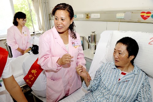 6月28日,在青島市中心醫(yī)院病房內(nèi),愛心大姐唐惠芳(中)在與來自汶川的傷員易顯蓮交流。 新華社記者 李紫恒 攝