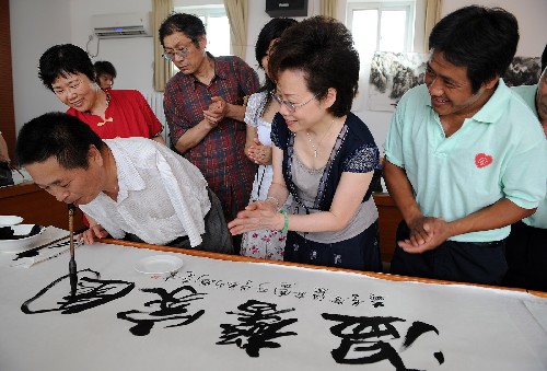 7月4日,鄭麗珠(前右二)等觀看北京市殘疾人書畫家劉京生(前左一)用口銜毛筆寫字。當(dāng)日,北京大興區(qū)長(zhǎng)子營鎮(zhèn)殘疾人溫馨家園舉行捐助儀式。北京愛心人士楊建宏和專程從臺(tái)灣趕到北京的國際口足畫藝協(xié)會(huì)秘書長(zhǎng)鄭麗珠向殘疾人溫馨家園捐贈(zèng)健身康復(fù)器材、電暖氣及書畫作品。 據(jù)介紹,北京殘疾人溫馨家園主要是依托社區(qū)內(nèi)的公共活動(dòng)中心為殘疾人提供綜合性活動(dòng)和服務(wù)的載體。廣大殘疾人可以不出社區(qū),即可得到康復(fù)、教育、就業(yè)、社會(huì)保障等各項(xiàng)服務(wù)。 新華社記者 張旭 攝