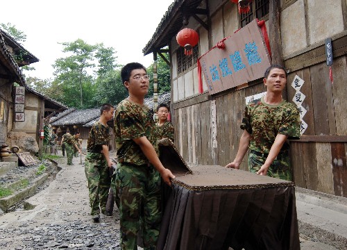 7月13日,濟(jì)南軍區(qū)裝甲師某團(tuán)的幾名官兵正在尋龍山風(fēng)景區(qū)內(nèi)的著名古鎮(zhèn)——龍隱鎮(zhèn)幫助景區(qū)清理物品。 新華社記者 劉潺 攝