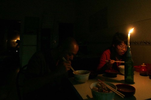 7月16日晚,客人在汶川縣城一家飯館內(nèi)借著燭光就餐。 新華社記者 魯金博 攝