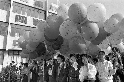 1991年5月11日,中國第一家高新技術(shù)交易市場(chǎng)——北京市新技術(shù)產(chǎn)業(yè)開發(fā)試驗(yàn)區(qū)科技貿(mào)易中心在中關(guān)村南部正式開業(yè)。這是技術(shù)開發(fā)區(qū)的職工手持彩球,參加開業(yè)典禮。 新華社發(fā)