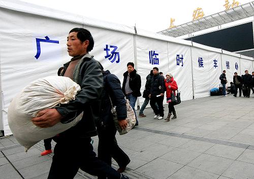 1月5日,旅客從上?;疖?chē)站臨時(shí)候車(chē)棚前走過(guò)。上海火車(chē)站在春運(yùn)前購(gòu)票高峰期間,特意在火車(chē)站廣場(chǎng)搭建起臨時(shí)候車(chē)棚,為南來(lái)北往的旅客遮風(fēng)擋雨。 新華社記者 陳飛 攝