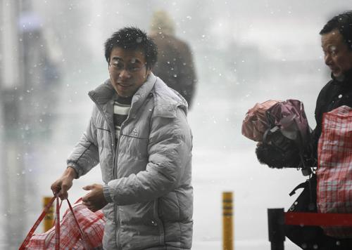 1月6日,一位旅客在武昌火車站準備進站候車。當日,武漢鐵路部門發(fā)送旅客預(yù)計超過10萬人次,許多旅客冒著風(fēng)雪踏上回家的旅途。 新華社記者 郝同前 攝