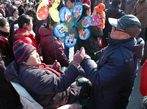 2月9日,家住北京南三環(huán)的老兩口騎三輪車來逛廠甸廟會(huì)。買了風(fēng)車后,二老檢查一下轉(zhuǎn)得怎樣。新華社記者楊嘉理攝