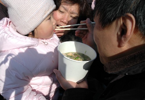 2月9日,北京廠甸廟會(huì)上,大人在給孩子喂上一口北京傳統(tǒng)小吃鹵煮火燒。大年初三,陽光和暖,北京廠甸廟會(huì)熙熙攘攘。市民、游客大都舉家出游,真?zhèn)€是老幼同樂,親情融融。新華社記者楊嘉理攝