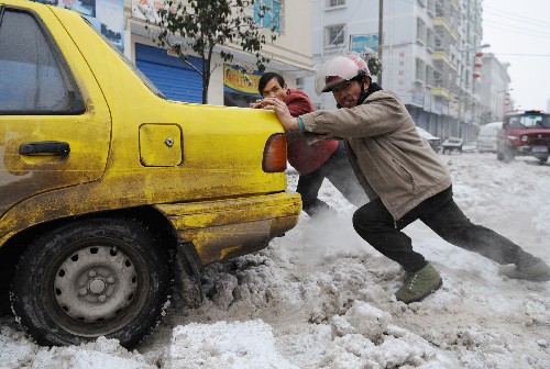 2月5日,貴州開陽縣兩位市民幫助一輛陷入雪中的汽車脫離困境。