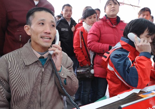 這是在福州火車站,返鄉(xiāng)的外來(lái)務(wù)工人員通過(guò)免費(fèi)電話與家人聯(lián)系(2月3日攝)。 新華社發(fā)