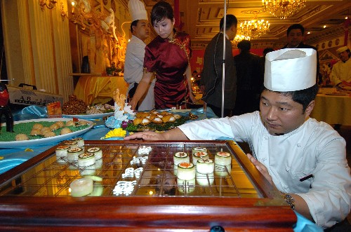 11月27日,北京便宜坊烤鴨店廚師在準(zhǔn)備名為《棋韻》的參賽菜品,這款形為中國象棋的熱菜由冬瓜、雞蛋、鴨絲、彩椒和巧克力等材料做成。 當(dāng)日,北京市崇文區(qū)飲食協(xié)會舉辦“與奧運(yùn)同行、為奧運(yùn)助力”特色創(chuàng)新菜品展示技能大賽,40余家參賽餐飲企業(yè)就創(chuàng)新菜品和提升奧運(yùn)接待服務(wù)水平進(jìn)行了交流。 新華社記者 張旭 攝