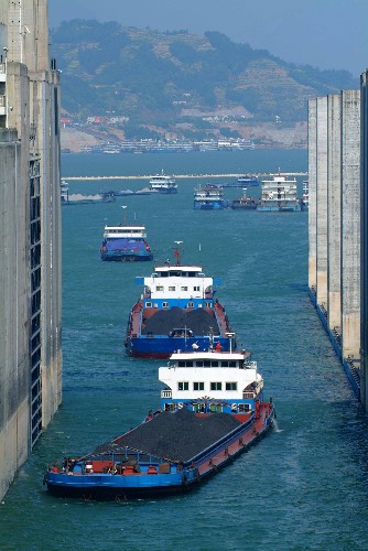 這是船舶通過(guò)三峽船閘上游引航道進(jìn)入船閘(2007年4月30日攝)。中國(guó)長(zhǎng)江三峽工程開(kāi)發(fā)總公司提供的信息資料顯示,三峽工程2007年過(guò)壩貨運(yùn)量突破6000萬(wàn)噸,達(dá)到6056.5萬(wàn)噸,比上年增長(zhǎng)21.3%。其中三峽船閘貨運(yùn)通過(guò)量為4685.9萬(wàn)噸,比上年增長(zhǎng)19%;翻壩轉(zhuǎn)運(yùn)貨物1370.6萬(wàn)噸,比上年增長(zhǎng)25.2%。三峽工程2003年蓄水至135米以來(lái),長(zhǎng)江上游航行條件極大改善,促使三峽庫(kù)區(qū)航運(yùn)業(yè)迅猛發(fā)展。2004年至2007年,通過(guò)三峽壩區(qū)的年貨運(yùn)量逐年遞增,平均年增12%。 新華社記者 杜華舉 攝