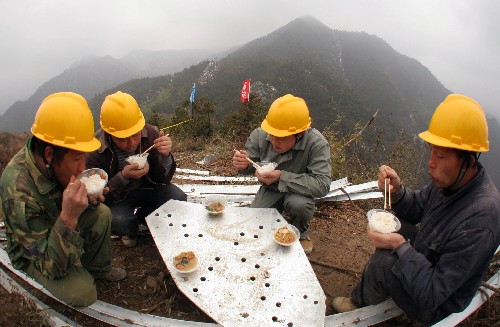 2月19日中午,江蘇南通供電公司員工在浙江麗水境內(nèi)的500千伏龍甌5464線103基鐵塔施工現(xiàn)場(chǎng)吃午飯。江蘇省電力公司援浙電網(wǎng)搶修突擊隊(duì)1000多名成員在高海拔、陡峭的11座山峰上承擔(dān)起搶修500千伏龍甌、雙甌線12基鐵塔的恢復(fù)重建等任務(wù)。施工人員克服困難,堅(jiān)持拆舊、塔材運(yùn)輸、組立新塔穿插同時(shí)進(jìn)行,到19日,12基鐵塔塔材全部到位,組立新塔已陸續(xù)開(kāi)始,12基塔建設(shè)任務(wù)將于3月上旬全部完成。 新華社發(fā)(許叢軍 攝)