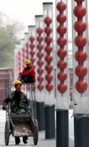 4月18日,一位施工人員推小車從北京前門大街路邊的冰糖葫蘆式路燈旁走過。 近日,鳥籠、冰糖葫蘆等具有老北京特色的路燈紛紛在改造施工中的北京前門大街現(xiàn)身。北京前門大街改造工程即將完工,將于今年“五一”亮相。 新華社發(fā)(吳長青 攝)