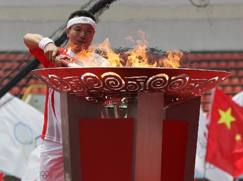 6月6日,在桂林市體育中心,最后一棒火炬手肖建剛點(diǎn)燃圣火盆。當(dāng)日,北京奧運(yùn)圣火在廣西桂林傳遞。 新華社記者周華攝