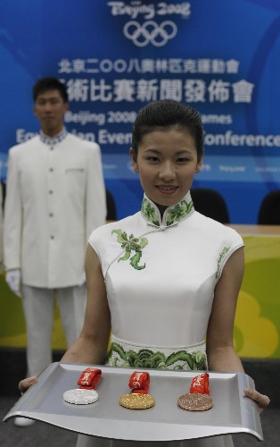 8月2日,奧運馬術(shù)比賽頒獎禮儀小姐向媒體展示金、銀、銅牌。當日,北京奧運會馬術(shù)比賽頒獎禮儀小姐、升旗手與馬術(shù)比賽的獎牌在香港亮相。 新華社記者 周磊 攝