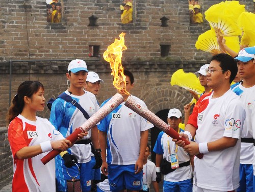 8月7日,火炬手顧崇華(右)與下一棒火炬手任金鳳交接。當(dāng)日,北京奧運(yùn)圣火在北京市傳遞。 新華社記者劉力航攝