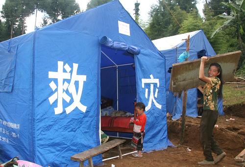 震中區(qū)勐弄鄉(xiāng)中山村的受災(zāi)婦女左萬兄(右)在倒塌的房屋中找回床板,非常開心(8月24日攝)。 位于中緬邊境的云南省德宏傣族景頗族自治州盈江縣境內(nèi)余震不斷。到目前為止,已發(fā)生余震719次,共造成人員5死112傷,近5萬戶21萬多人受災(zāi),民房倒塌、損毀、開裂11萬余間。在社會(huì)各界支援下,震區(qū)受災(zāi)各族群眾在頻頻余震中,開始互幫自助,恢復(fù)重建家園。 新華社記者陳海寧攝