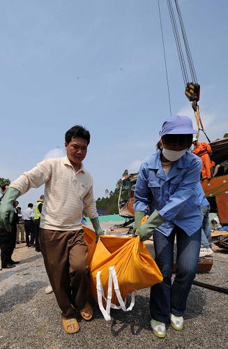 2月22日,救援人員在事故現(xiàn)場搬運遇難者遺體。 當(dāng)日凌晨,廣西南寧-北海方向高速公路122公里+600米處發(fā)生一起特大車禍。截至記者發(fā)稿時,車禍已造成12人死亡。 據(jù)了解,車牌號為“貴J02462”的省際快班從貴州都勻平塘開往廣東東莞。在行駛到上述路段時因緊急避讓前面大貨車灑落的大量麥麩,造成大客車側(cè)翻,車輛損毀嚴重。 新華社記者 周華攝