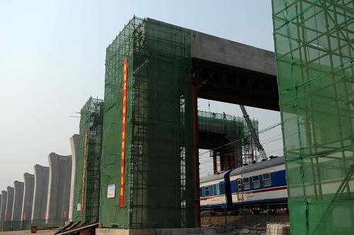 9月11日,列車從滬寧城際鐵路丹陽(yáng)段跨京滬鐵路的門式橋墩下駛過(guò)。 滬寧城際鐵路是長(zhǎng)三角地區(qū)城際軌道交通網(wǎng)規(guī)劃中的網(wǎng)絡(luò)主軸之一,線路全長(zhǎng)297公里,總投資約422億元,計(jì)劃于2010年7月建成通車。屆時(shí)列車時(shí)速可達(dá)300公里以上,從上海至南京只需75分鐘,旅客列車班次最小間隔時(shí)間只有3分鐘,沿線的上海、蘇州、南京等城市之間將實(shí)現(xiàn)鐵路列車公交化。 新華社發(fā)(劉兵生 攝)