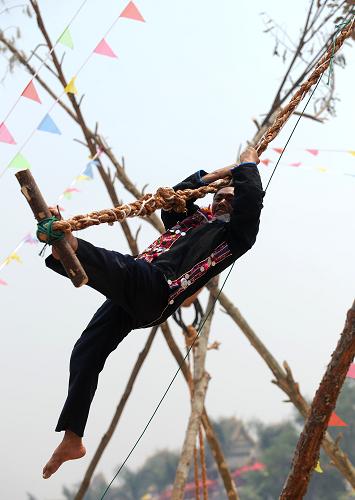 一名哈尼族男子在西雙版納景洪市表演蕩秋千(4月13日攝)。 從4月13日開始,2010年西雙版納潑水節(jié)暨傣歷1372年新年節(jié)在云南省西雙版納傣族自治州舉行。西雙版納景洪市舉行了豐富多彩的少數(shù)民族民間民俗活動,如賽龍舟、放孔明燈、蕩秋千、斗雞等,為節(jié)日增添了喜慶氣氛,吸引眾多海內(nèi)外游客前來觀賞。 新華社記者 藺以光 攝