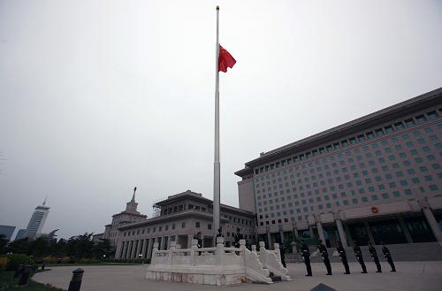 4月21日,北京解放軍八一大樓前國旗升起后,緩緩降下半旗向玉樹地震遇難同胞志哀。新華社記者王建民攝