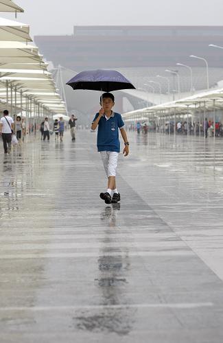 6月14日,一名小參觀者冒雨在上海世博園參觀。 當(dāng)日是端午節(jié)小長(zhǎng)假的第一天,上海世博園的小雨不減游客熱情。截至15時(shí),當(dāng)日入園人數(shù)突破46.19萬(wàn)。 新華社記者 沈伯韓 攝
