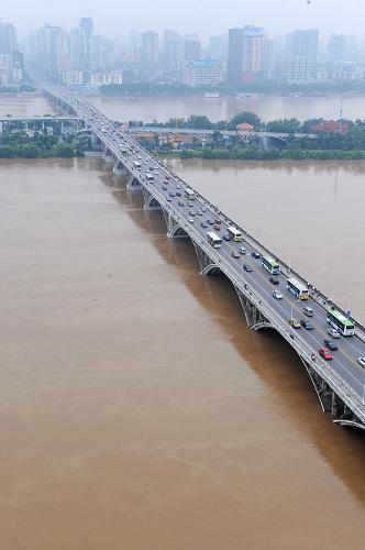 洪峰過境時的長沙湘江橘子洲大橋(6月23日攝)。 當(dāng)日,湘江今年入汛以來的最高洪峰順利通過長沙城。據(jù)長沙水文站介紹,受強降雨連日襲擊湖南的影響,6月22日19時,湘江長沙段出現(xiàn)了37米洪峰水位,超警戒水位1米,這也是今年以來湘江長沙段出現(xiàn)的最高水位。截至23日10時,湘江長沙段水位已回落到36.79米。目前,長沙市防汛抗旱指揮部已下發(fā)緊急通知,要求各相關(guān)部門采取各項措施確保安全度汛。 新華社記者 龍弘濤 攝